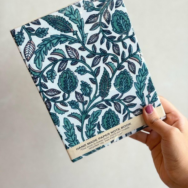 A hardbound journal wrapped in teal botanical block print fabric.