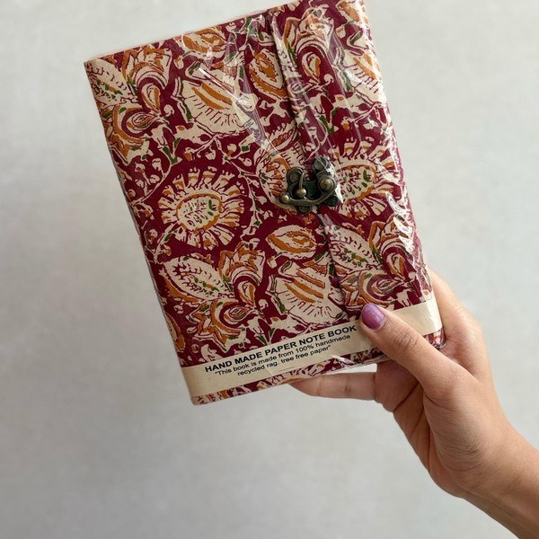 A paisley hand block printed notebook in red and cream with a vintage metal clasp.